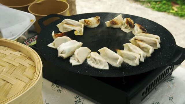 Dumpling cooking close up. Street food on portable gas stove. Outdoor cooking.