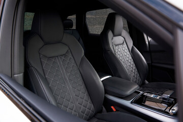 The view from the passenger seat in the car is impressive. The dark interior of the car is contrasted with light stitching, creating a unique and stylish look.