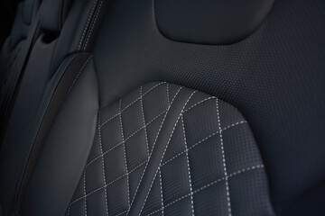 The details of the rear row upholstery in the car are impressive. The dark car interior is enhanced by the light stitching