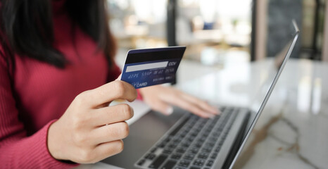 Woman shopping on laptop holding credit card for Internet online e-commerce shopping spending money Online shopping Mobile phone laptop technology concept