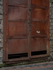 Large closed rusty door. Iron old gate.