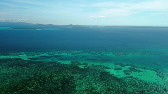 Wide aerial seascape near Canabungan Island in Balabac Palawan Philippines with turquoise reef shallows and deep blue open water