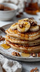 Delicious Pancakes with Banana Slices, Walnuts, and Maple Syrup