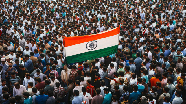 A sea of people gathered in a large crowd, holding high the Indian national flag amidst a vibrant atmosphere of unity and patriotism.