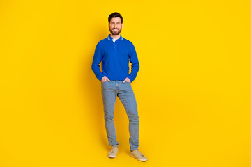 Fototapeta premium Full length photo of handsome young guy posing model dressed stylish blue garment isolated on yellow color background