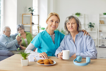 Obraz premium Caring smiling nurse, geriatric medicine caretaker providing senior woman help, support, aged old granny medical visit, female doctor close with elder lady, give empathy, encourage patient healthcare 