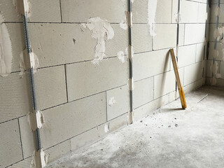 A wooden block is leaning against the aerated concrete wall of a house.