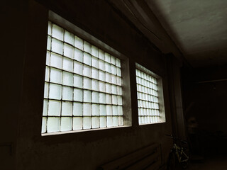 A window made of green glass blocks in a dark room