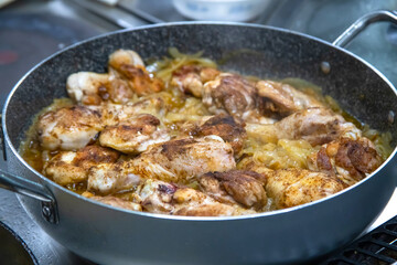 Pans with chicken meat stand on the stove, frying chicken, cooking, real picture in the kitchen