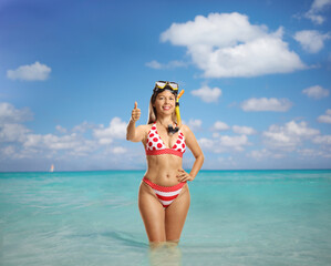 Young woman in bikini with a snorkeling mask standing in the sea