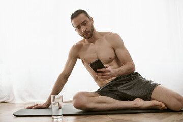 At-home yoga practitioner on mat uses cell phone for morning session.
