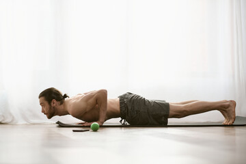 Obraz premium A man gracefully stretches at home.