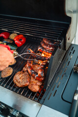 Roasted Sausages Getting Grilled over the Hot Bursting Flames on a Gas Grill with other Grill Food