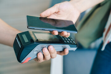 Close-up shot of person paying by credit card at POS device