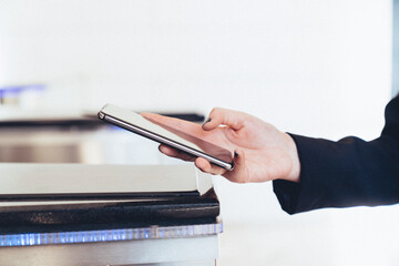 A person is using a cell phone to pay for something. Using the phone for secure passage