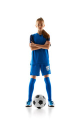 Focused teen girl in blue uniform, soccer player standing with ball, posing isolated on white studio background. Concept of sport, active and healthy lifestyle, childhood, school, hobby © master1305