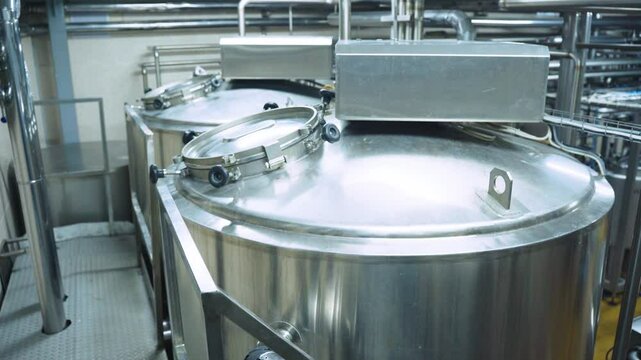 Container cistern for storing milk and dairy products, modern dairy factory. Milk pasteurization, dairy industry. Food plant, warehouse. Milk, dairy products, storage. Modern equipment, barrels milk