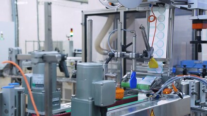 Modern automatic line for labeling dairy products in cans at a dairy factory. The machine automatically marks filled milk cans. Modern dairy mass production. Food industry, dairy plant, conveyor belt