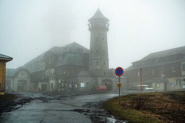 Fototapeta premium Hill Klinovec in Ore mountain with dirty old damaged building and lookout tower.