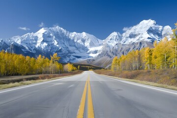 Scenic mountain road framed by autumn trees and snow-capped peaks under a clear blue sky.