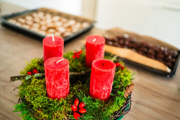 Beautiful Traditional Advents Wreath with Big Red Candles and Christmas Tree Branches with Rose Hips on the First Advent and a Burnt Wick