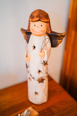 Smiling Angle Statue Holding a Star Standing on a Wooden Cupboard for Christmas