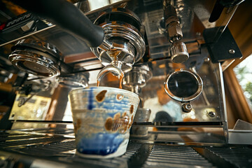 Close up of coffee machine pouring espresso in cafe