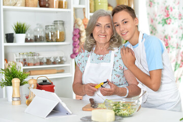 Grandmother and grandson preparing salad in the kitchen
