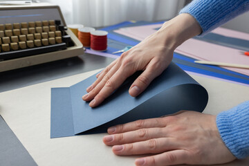 High-quality image of a person binding a book using traditional coptic stitch technique. DIY bookbinding, handcrafting, artisan book, handmade, coptic stitch, binding tools, creative, detailed process