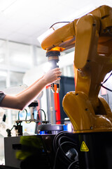 Professional and intelligence female engineer used her technical hard skill to fix, repair or maintenance machine robotic arm in factory or industrial, examining or welding automobile machine workshop