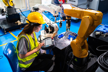 Professional and intelligence female engineer used her technical hard skill to fix, repair or maintenance machine robotic arm in factory or industrial, examining or welding automobile machine workshop