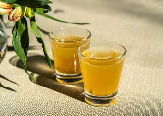 Passion fruit cold drink, welcome drinks set, yellow iced tea, fruit cocktails in small glass with ice on restaurant table
