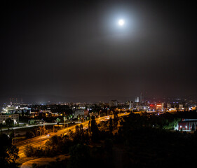 The bright moon shines over the night lights of Sofia, the capital city of Bulgaria, in Eastern Europe.