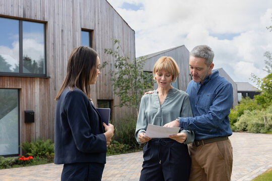 Eco conscious couple looking at details of a passive house for sale
