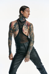 A young man displaying intricate tattoos and various piercings on his chest, exuding a sense of self-expression and artistry.