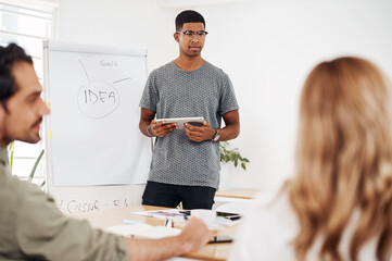Businessman, tablet and presentation with team in meeting for idea, goals or brainstorming at...