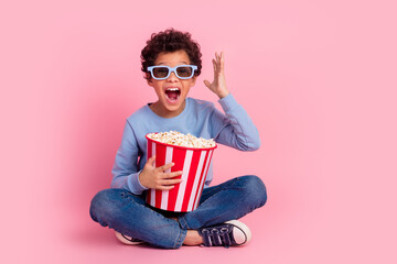 Full length photo of excited cool son dressed blue sweatshirt enjoying film eating pop corn emtpy space isolated pink color background