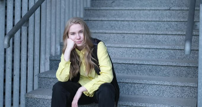 Beautiful blond female office worker on the background of office building . Positive emotions, wearing yellow shirt and jacket. video footage 4k