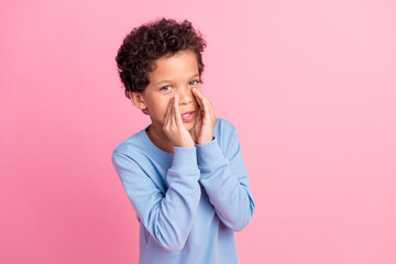 Photo of funky cool son dressed blue sweatshirt telling you secret emtpy space isolated pink color background