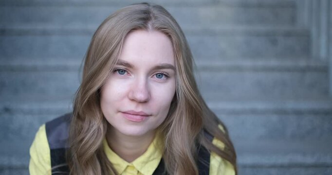 Beautiful blond female office worker on the background of office building . Positive emotions, wearing yellow shirt and jacket. video footage 4k