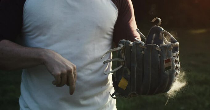 Super slow motion of baseball player practice with ball during workout before competition game match on baseball stadium on sunset at 1000 fps.