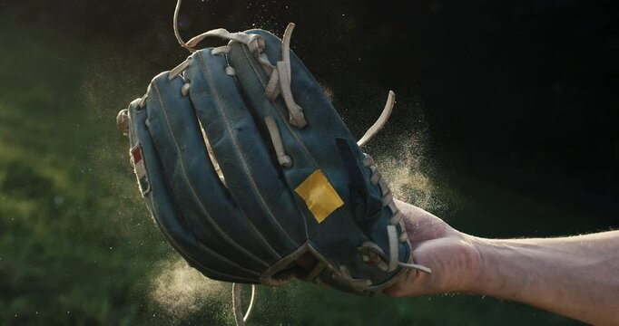 Super slow motion macro of baseball player catches ball during competition game match on baseball stadium on sunset at 1000 fps.