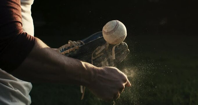 Super slow motion of baseball player practice with ball during workout before competition game match on baseball stadium on sunset at 1000 fps.