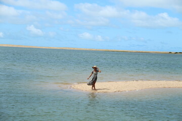 mulher de chapéu e vestido na ilha do guajiru, ceará 