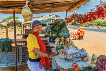 african woman street vendor, selling eggs and vegetables, self employed