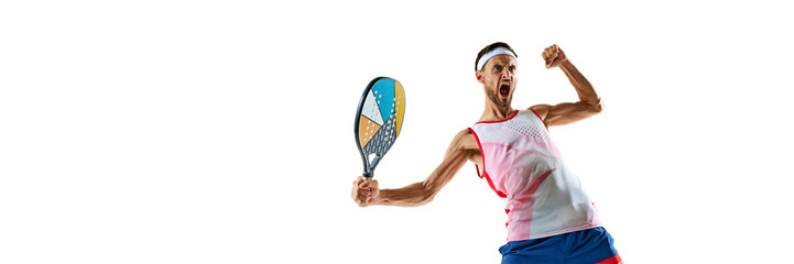 Champion. Young man, tennis player in uniform with colorful padel racket showing his motivation and ambitions, winning emotions isolated on white background. Sport, hobby, games, competition concept © master1305
