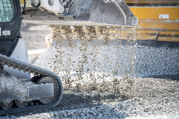 Skid loader dumping gravel