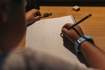 Young student doing his homework after school. Teenager boy writing homework concentrating on...