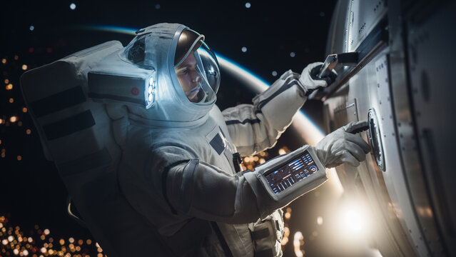 Professional Space Engineer Servicing a Panel on a Communication Satellite. Brave Caucasian Male Astronaut Working in Outer Space with Beautiful Dark Side of Planet Earth in the Background