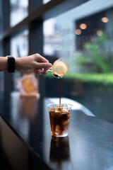 a person is pouring a coffee with a ice cube